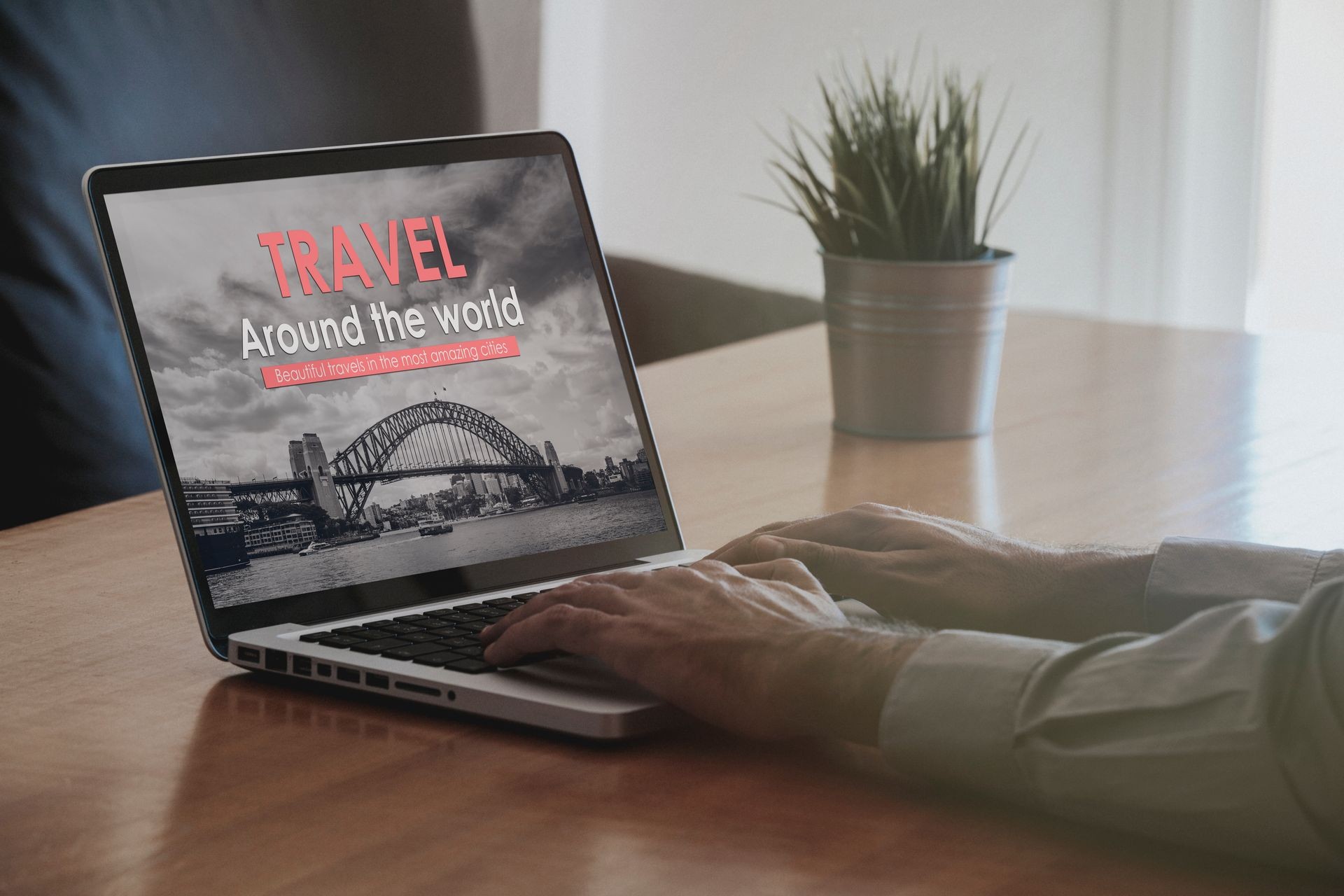 Travel agency website in a laptop screen on a wooden table, while man search for travel landmarks.